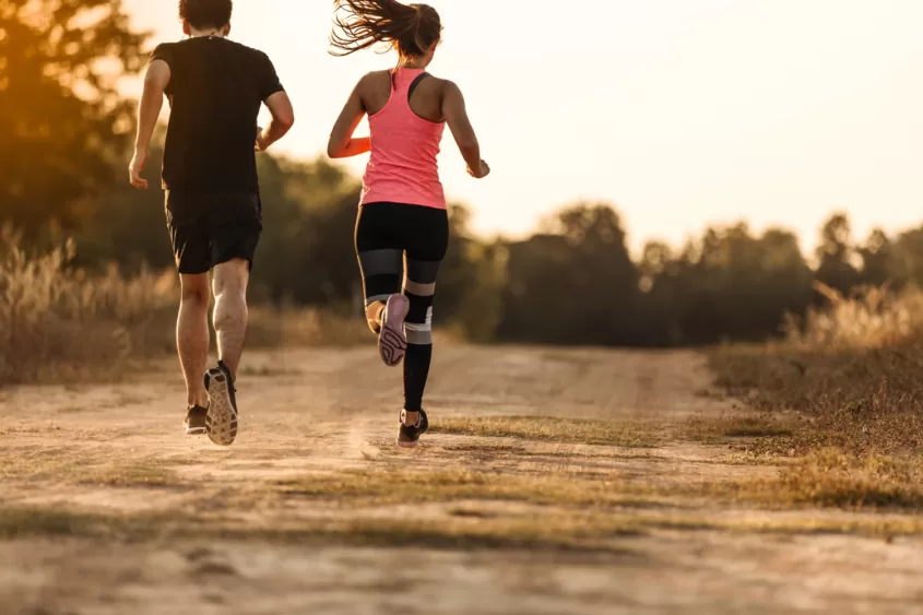 young-couple-running-forest-trail-845x563